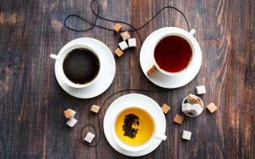 three cups of coffee and tea on wooden table