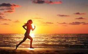 woman running on a beach during sunset