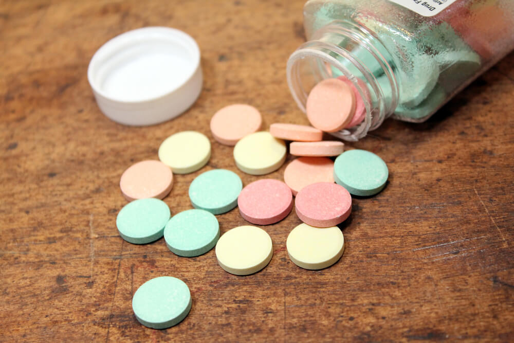 colorful antacids spilled on a wood table